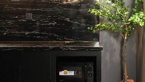A modern kitchen with a black countertop, a coffee machine, and a built-in espresso maker. - Kin Wander Tan Binh, The Mountain (Ho Chi Minh City)