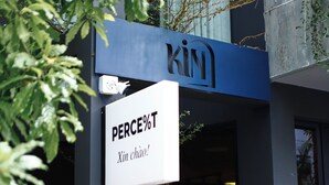A building with a sign that reads "KIN" and another sign below it that says "PERCE%T Xin chào!". - Kin Wander Tan Binh, The Mountain (Ho Chi Minh City)
