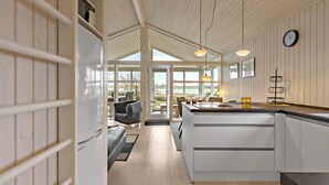 A modern kitchen with a central island, wooden flooring, and a view of the outdoors. - 2 bedroom nice home in Kerteminde (Kerteminde)