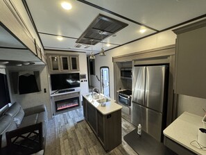 A compact kitchen with a built-in oven, microwave, and stainless steel refrigerator. - Huge RV-Lake Russel & Lake Secession Camplife - Hunting and Fishing Playground (Iva)