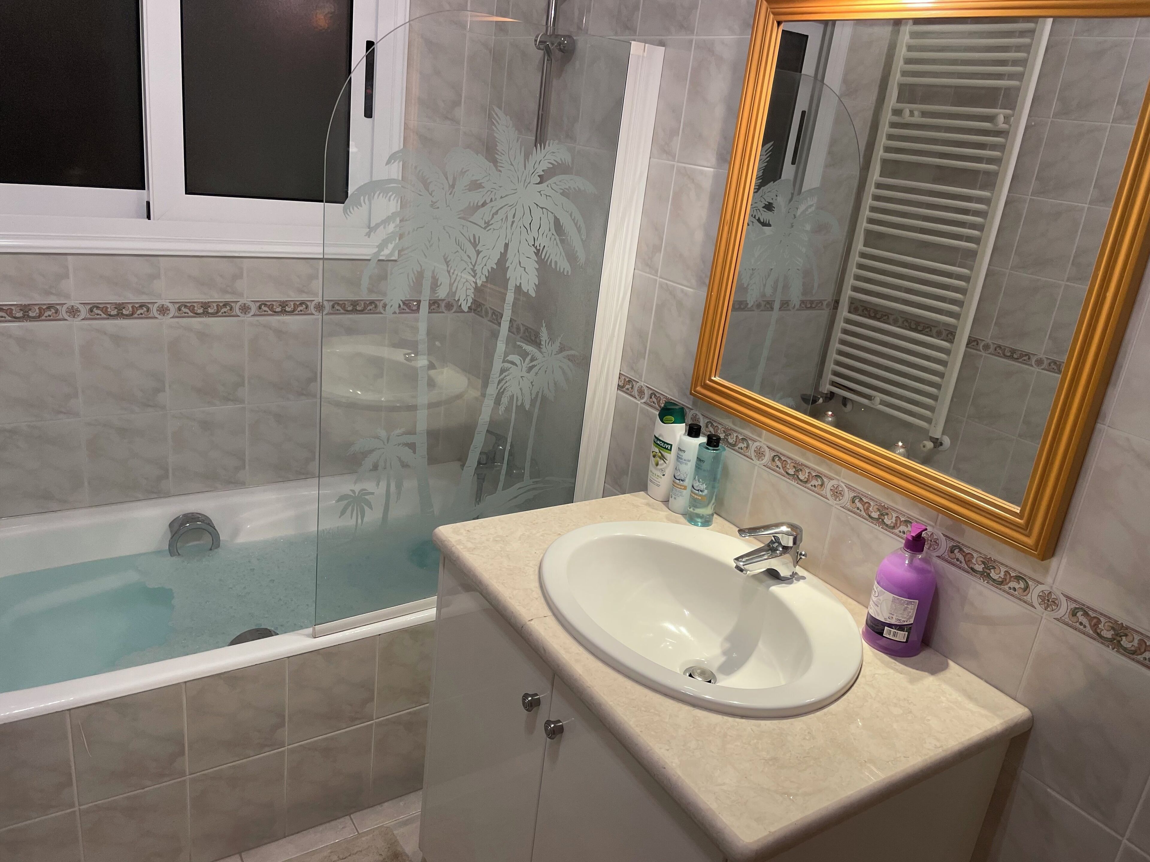 Une salle de bain avec une baignoire, un lavabo, un miroir et une douche.