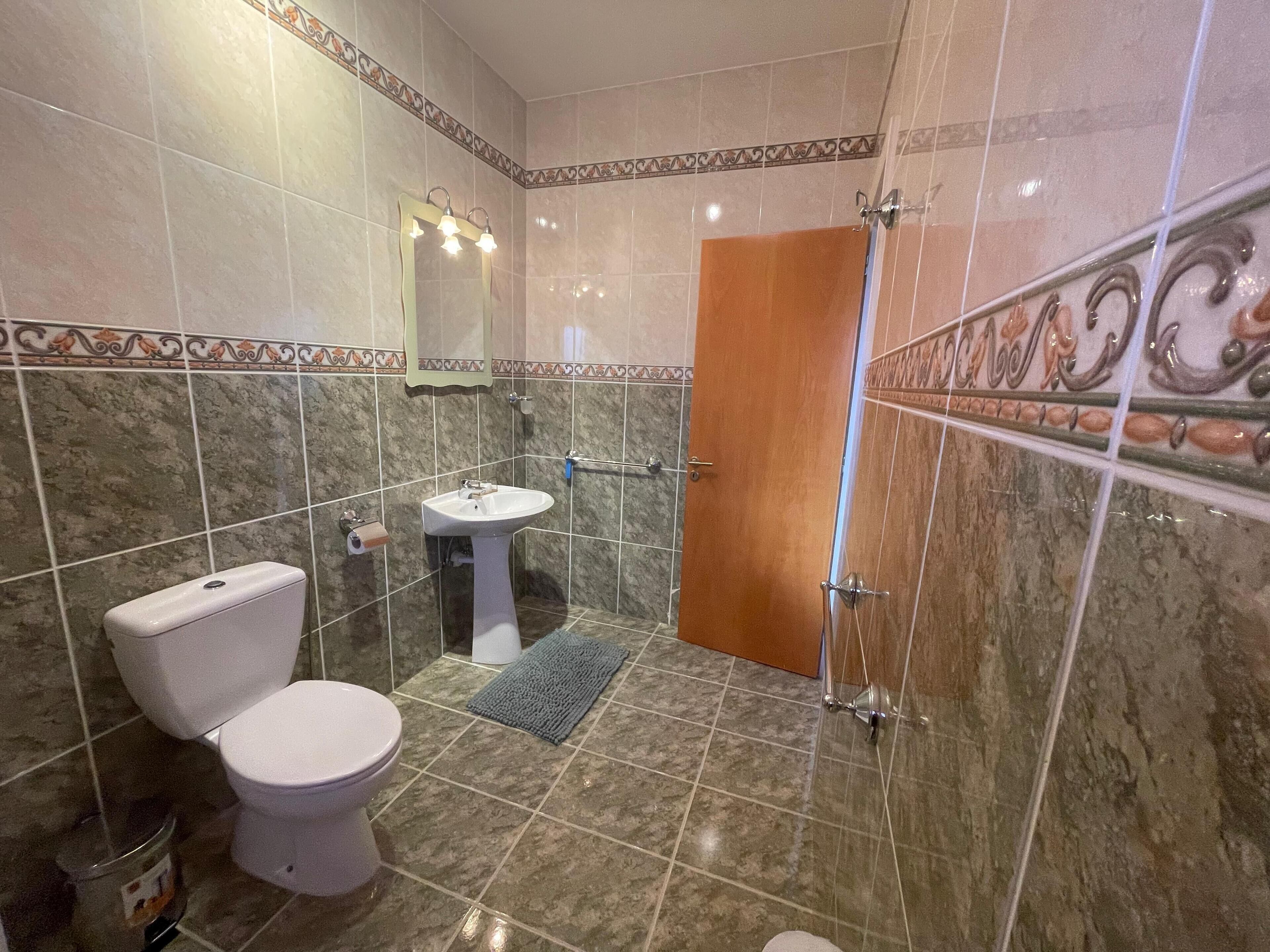 Ein Badezimmer mit Toilette, Waschbecken und Dusche.