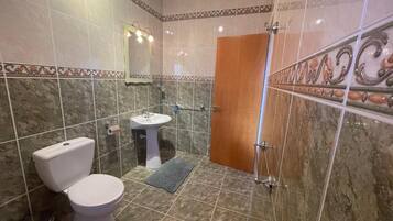 Ein Badezimmer mit Toilette, Waschbecken und Dusche.