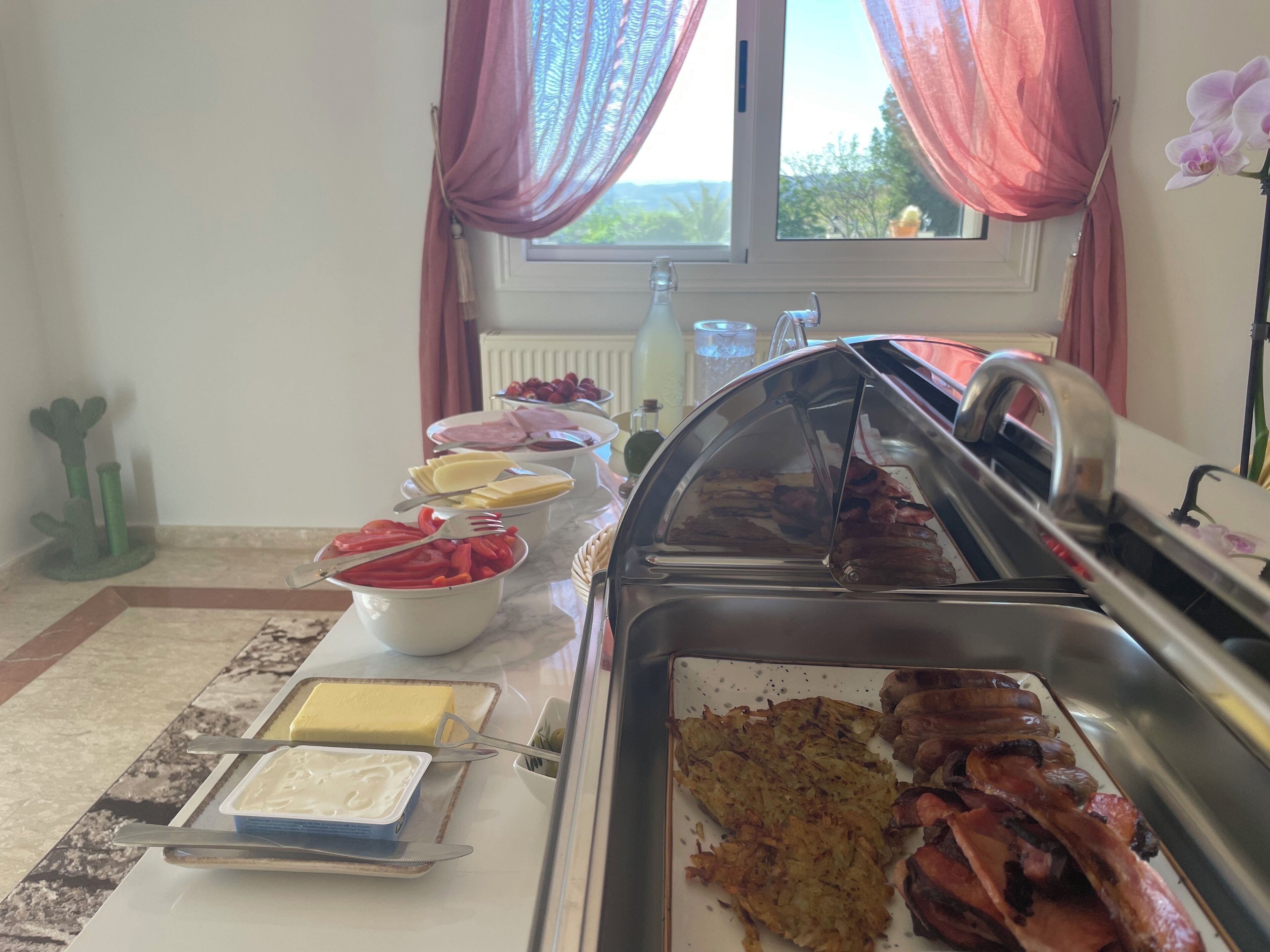 A buffet setup with various food items including meats, cheeses, and vegetables.