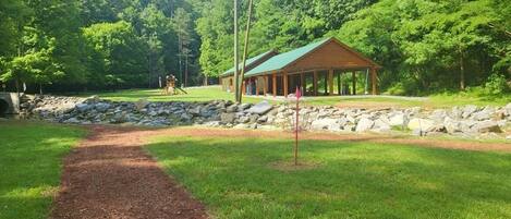 A lodge with a covered porch and a stone wall.