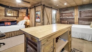 A room with a wooden ceiling, a bed, a desk, and a chair.
