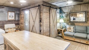 Ein rustikales Interieur mit einem Holztisch, einer Couch und einem Deckenventilator.