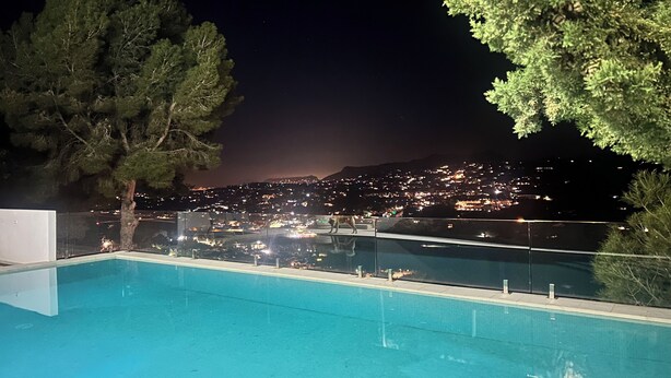 Ein Pool mit Blick auf eine beleuchtete Stadt.
