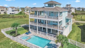 A multi-story residential building with a pool and a fenced deck area.