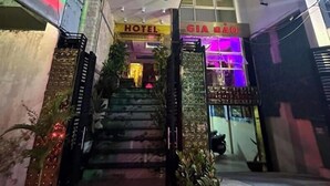 A hotel entrance with a staircase leading to the lobby, a sign reading "HOTEL GIA DAO," and a large digital display on the left. - Gia Bao Hotel Binh Thanh - by BayLuxury (Ho Chi Minh City)
