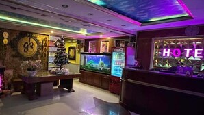 A hotel lobby with a large TV, a Coca-Cola refrigerator, and a Christmas tree. - Gia Bao Hotel Binh Thanh - by BayLuxury (Ho Chi Minh City)
