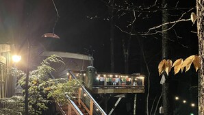 A snow-covered outdoor area with wooden stairs leading to a covered seating area. - A yurt in the trees.  Close to Portland but close to nature.  Treeyurt Maine (Cumberland)
