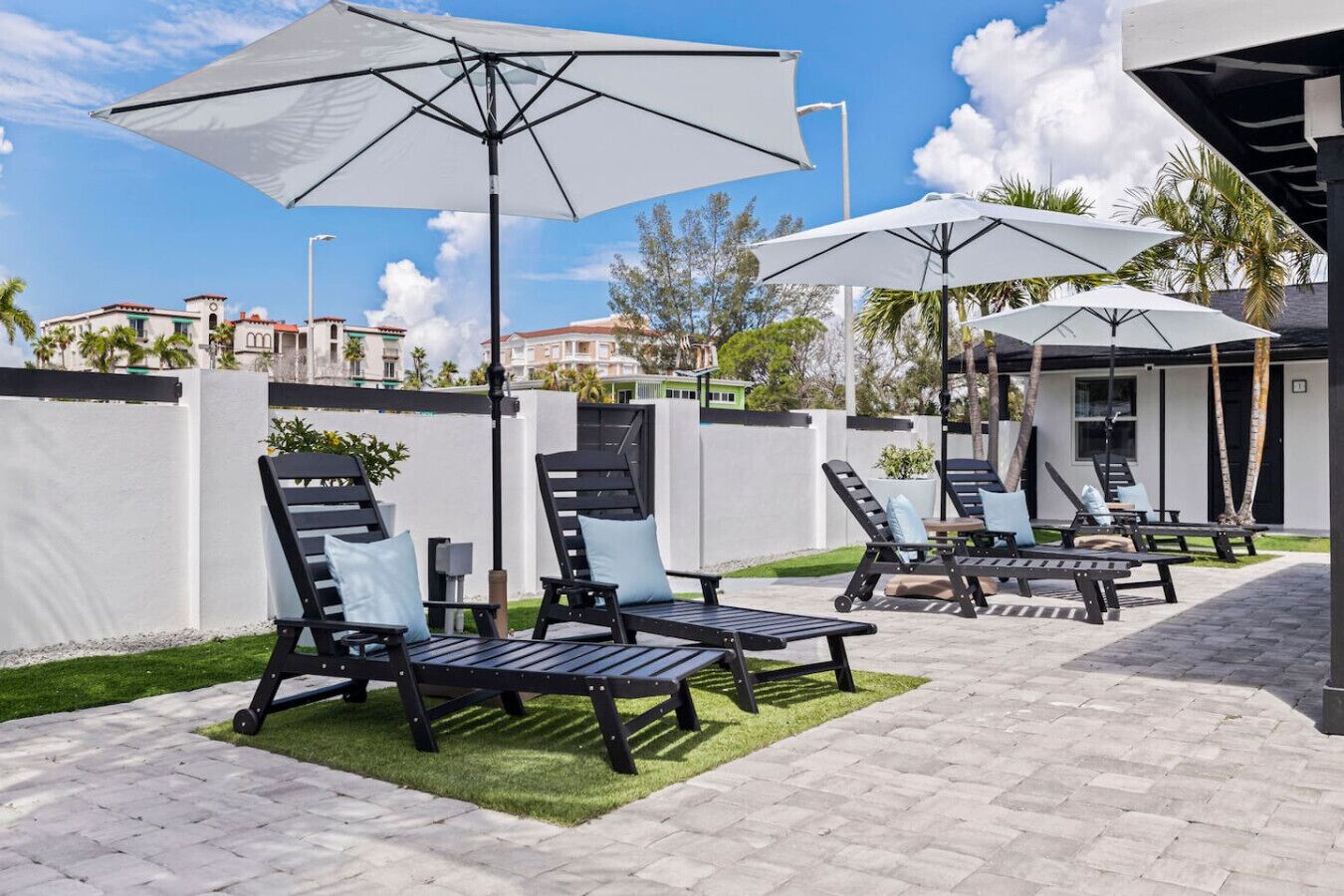 A patio area with outdoor seating, umbrellas, and a view of the surrounding buildings.