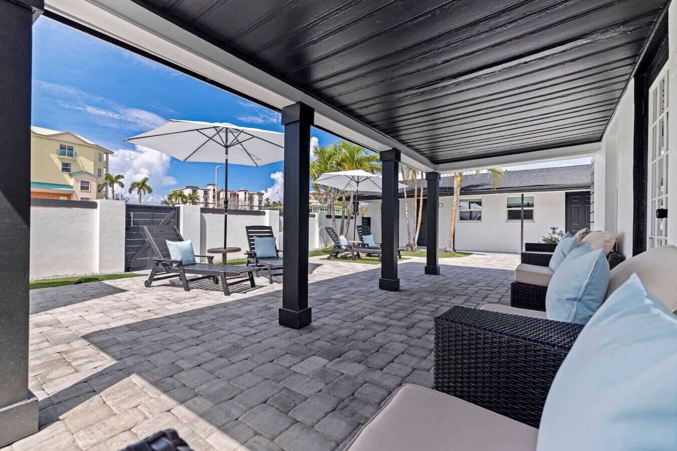 Eine Außenpatio-Terrasse mit Sitzgelegenheiten, Sonnenschirmen und Blick auf die umliegenden Gebäude.