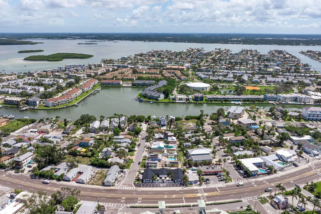A residential area with houses, a marina, and a large body of water.