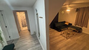 Una sala de estar con un sofá, una mesa de centro y una escalera que lleva a otra habitación.