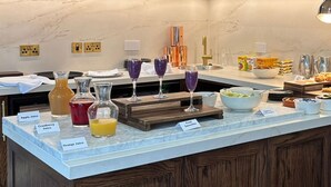 A breakfast buffet with labeled juice dispensers and a variety of food items. - TheHillbrookSherborne (Sherborne)