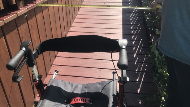 Een houten terras met een fiets en een meetlint.