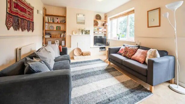 A cozy living room with a sofa, a coffee table, and a bookshelf.