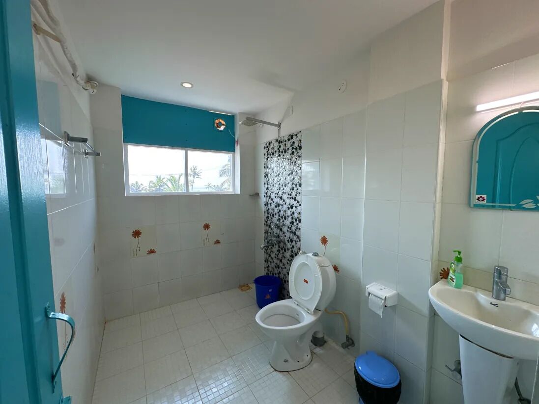 A bathroom with a toilet, sink, and shower.