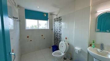 A bathroom with a toilet, sink, and shower.