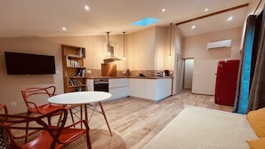 A compact living space with a kitchenette, dining area, and a sofa.
