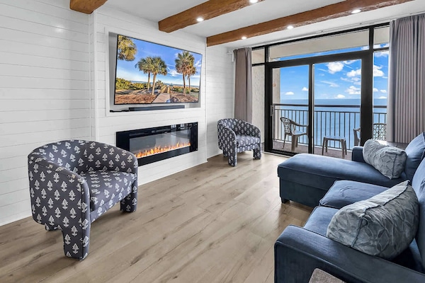 Enjoy the living room space with wooden beams, Alexa-controlled motorized blinds, an electric fireplace, and a 70" LG Smart TV.