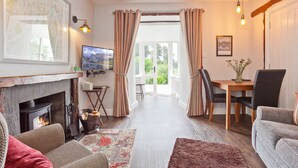 Una sala de estar acogedora con chimenea, televisor y comedor con mesa y sillas.