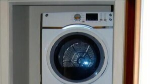 Une machine à laver et un sèche-linge superposés dans une buanderie.