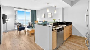 Une cuisine moderne dotée d’un îlot central, de meubles en bois et d’un lave-vaisselle en acier inoxydable.