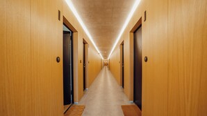 A long, narrow hallway with wooden walls and doors, leading to multiple rooms. - Amazing Design Garden by Vacationy (Vila Nova de Gaia)