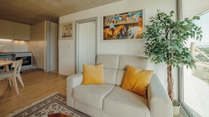 A modern living room with a sofa, a dining area, and a kitchen. - Amazing Design Garden by Vacationy (Vila Nova de Gaia)
