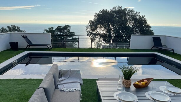 Eine moderne Außenpatio mit Pool, Sitzgelegenheit und einem Esstisch.