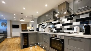 Une cuisine moderne avec des meubles gris, un four encastré et un four à micro-ondes.