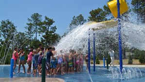 Ein Wasserspielbereich mit mehreren Wasserstrahlen und einer gelben Wasserspielelemente.