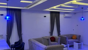 Una sala de estar moderna con sofá, sillones y comedor.