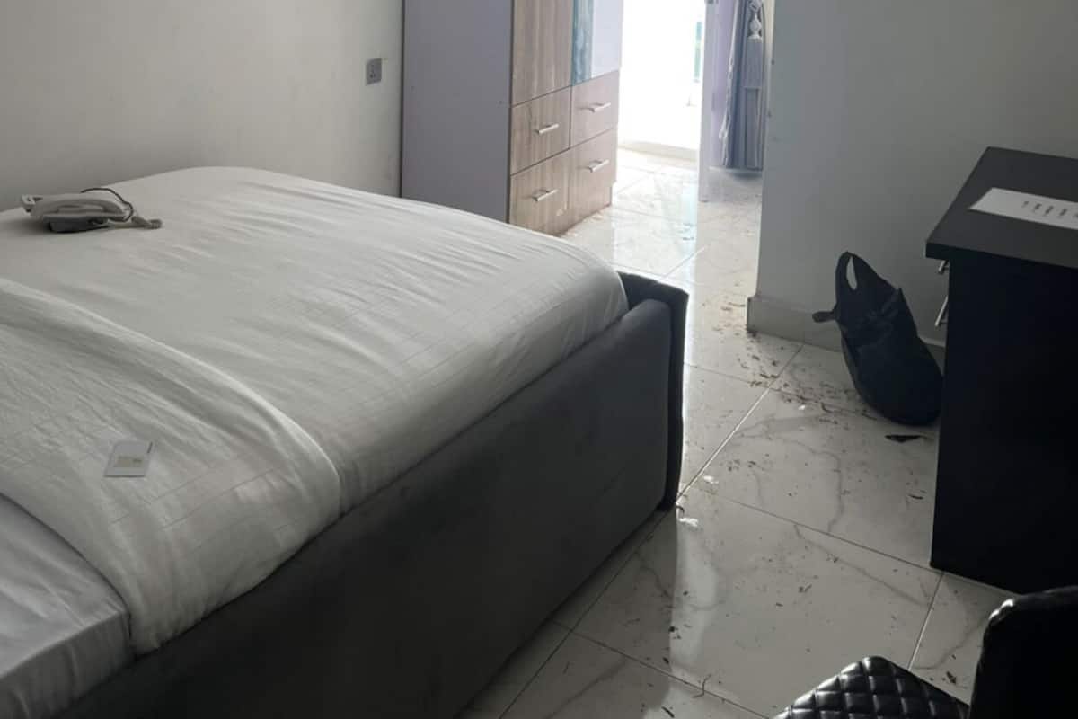 Une chambre à coucher comprenant un lit, une armoire, un bureau et un luminaire suspendu.