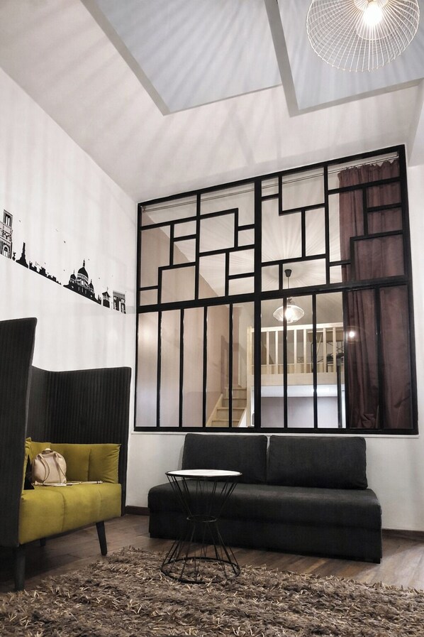 Un soggiorno moderno con un divano, un tavolino e un pannello decorativo.