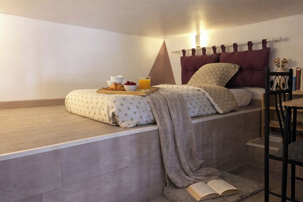 Un dormitorio con cama, mesita de noche y una silla.