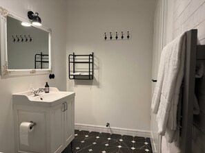 A bathroom with a white vanity, a mirror with an ornate frame, a black towel rack, a black towel rack, a black towel rack, a black towel rack, a black towel rack, a black towel rack, a black towel rack, a black towel rack, a black towel rack, a black towel rack, a black towel rack, a black towel rack, a black towel rack, a black towel rack, a black towel rack, a black towel rack, a black towel rack, a black towel rack, a black towel rack, a black towel rack, a black towel rack, a black towel rack, a black towel rack, a black towel rack, a black towel rack, a black towel rack, a black towel rack, a black towel rack, a black towel rack, a black towel rack, a black towel rack, a black towel rack, a black towel rack, a black towel rack, a black towel rack, a black towel rack, a black towel - Hotel Stafholt (Borgarbyggd)