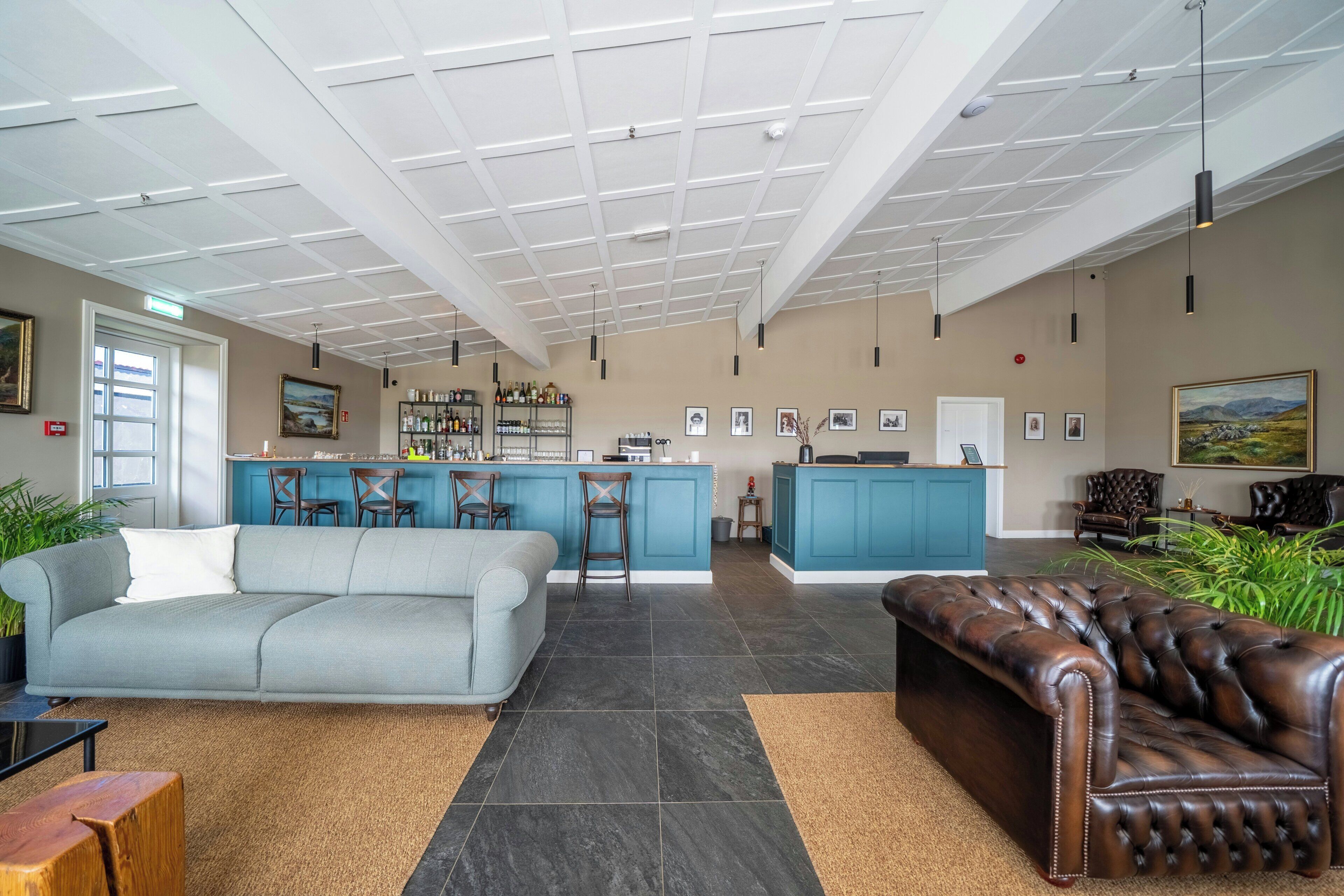 Un amplio salón con sofá, sofá de cuero, una isla de cocina y una zona de bar.