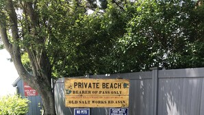 A private beach sign with restrictions and a wooden fence. - Cozy beach cottage. Less than a 2minute walk to the beach.  (Westbrook)