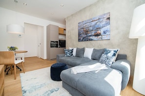 Relax in this stylish living space with a sofa, dining area, and modern kitchen.