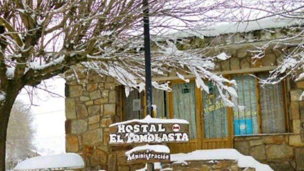 A stone building with a sign reading "Hostal El Tomolasta."