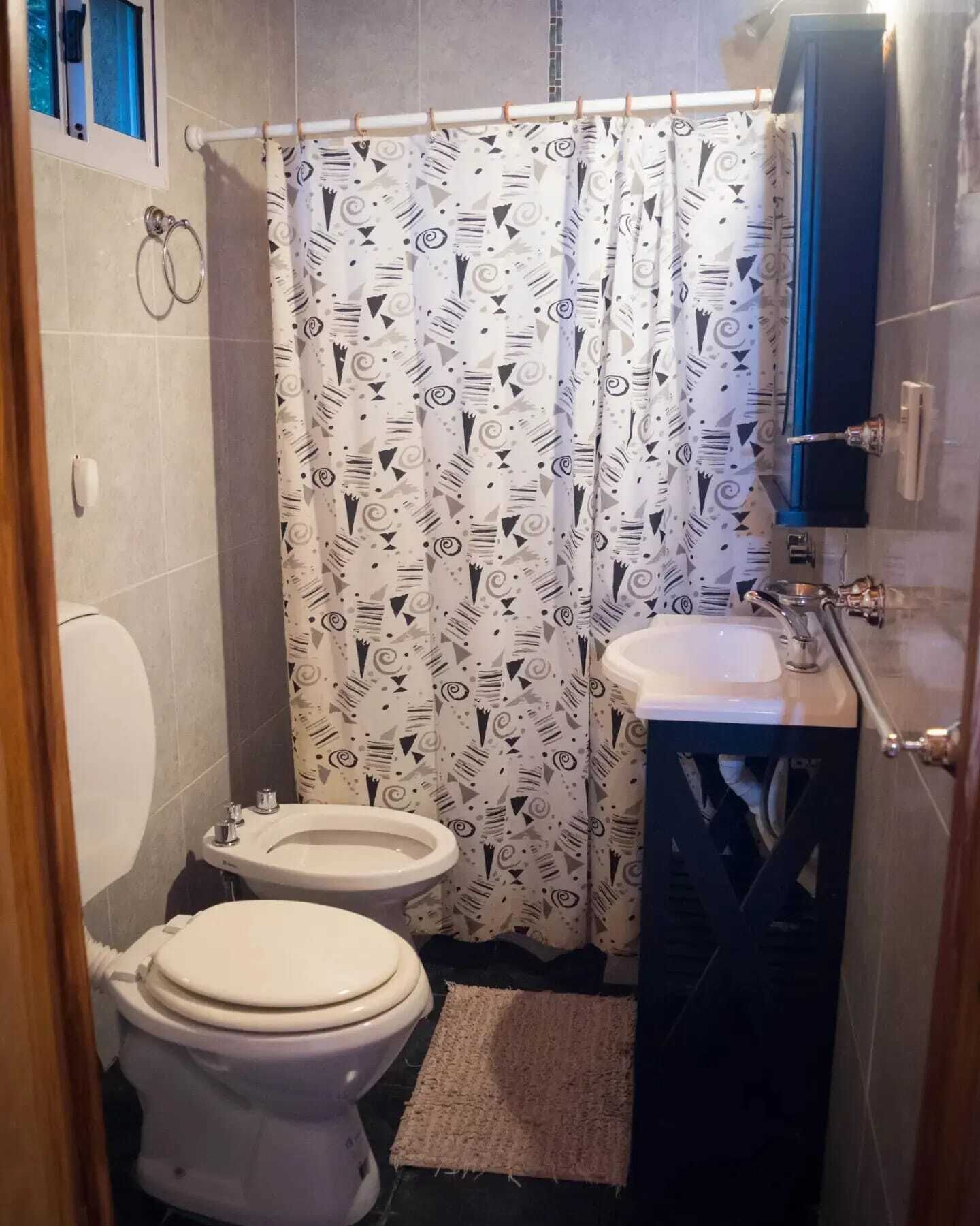 Un baño pequeño con inodoro, bidé y lavamanos.