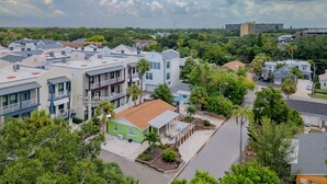 A residential area with a mix of modern and traditional houses, including a green house with a small patio. - Downtown Dunedin Cottage • Walk to Restaurants (Dunedin)