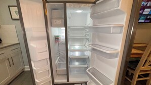 Ein offener Kühlschrank mit mehreren Ablagen und einem Gefrierfach.