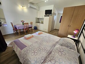 Una camera da letto con un letto, una scrivania con sedia, un armadio e una televisione.