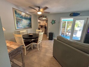 A dining area with a round table, chairs, and a ceiling fan.