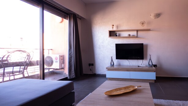 A modern living room with a flat-screen TV, a wooden coffee table, and a sofa.